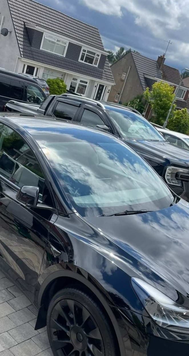 Black Tesla with mirror-finish reflections after a detail
