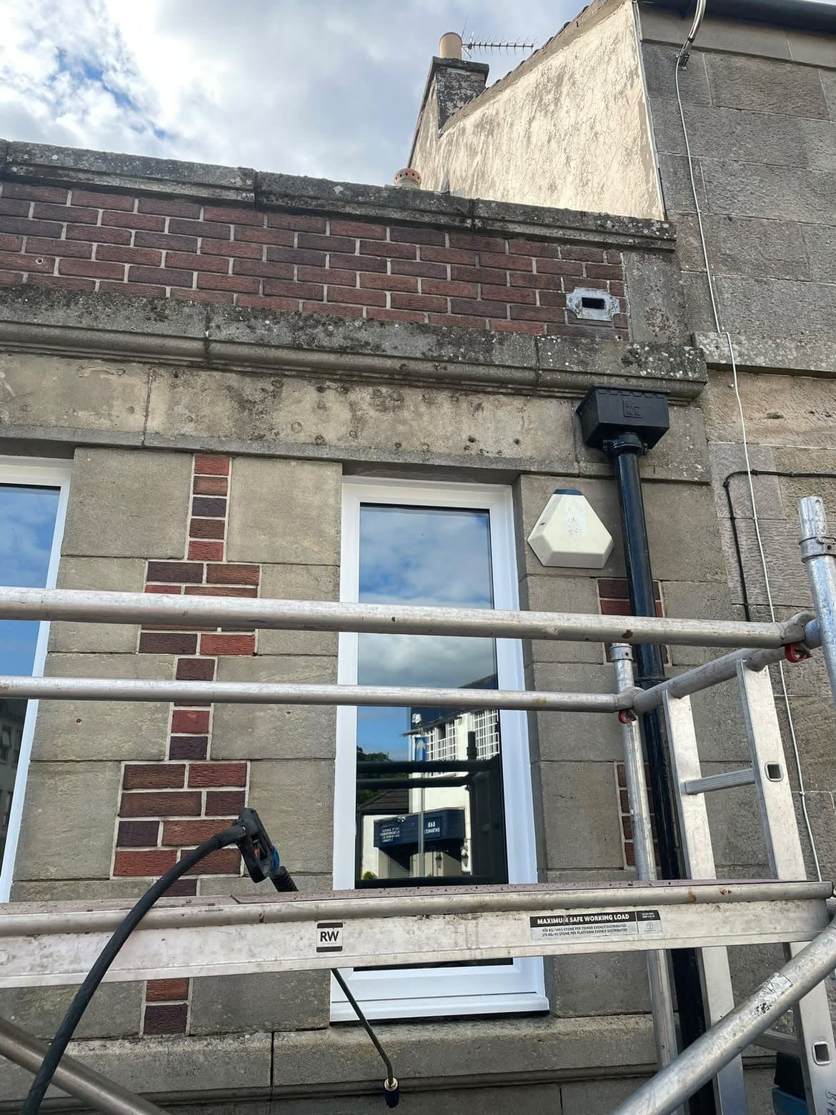 Cleaning the stone frontage of a commercial building from scaffolding