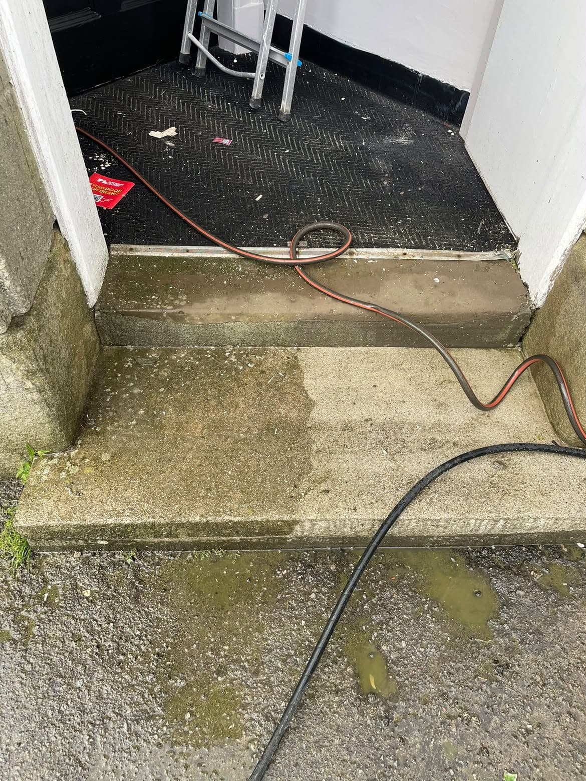 Concrete doorstep partly cleaned of moss and algae