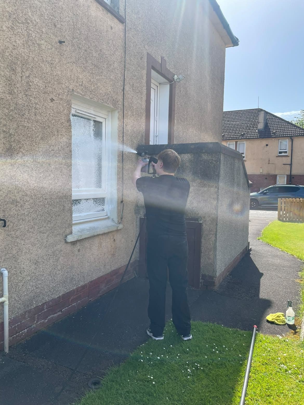 Low-pressure rinse of render on the gable end of a house